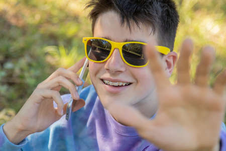 young teenager in the field with mobile phoneの写真素材