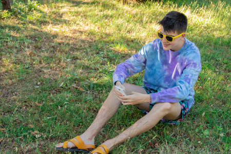 young teenager in the field with mobile phone
