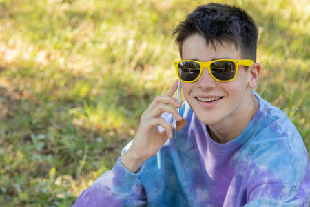 young teenager in the field with mobile phoneの写真素材