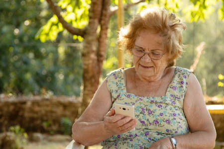 senior woman with mobile phone outdoors