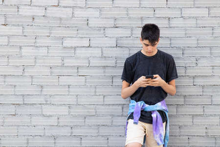 teenage student on the street with mobile phoneの写真素材