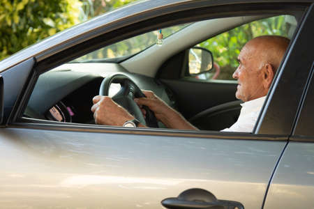 portrait of senior male driving car