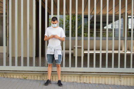 young man in the city with mask and mobile phone