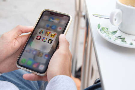 Galicia, Spain - August 21, 2020: hands with mobile phone with app and game logosのeditorial素材
