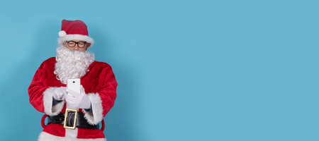 santa claus isolated on background with mobile phoneの写真素材