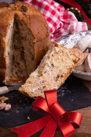 portion of panettone cut on the table with christmas decorations