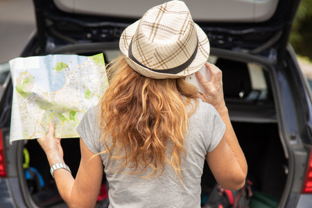 woman traveling by car with mobile phone and mapの写真素材