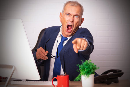 angry yelling businessman in officeの写真素材