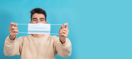 young male with sanitary mask against coronavirus isolated on backgroundの写真素材