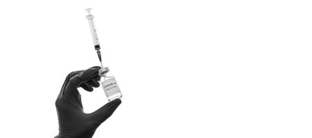 hand with vaccine and syringe in black and white isolated on backgroundの写真素材