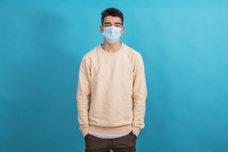 young male with sanitary mask against coronavirus isolated on backgroundの写真素材