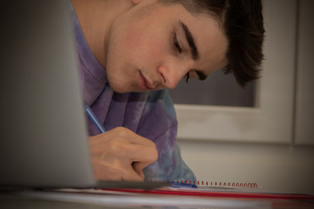 student at home with computer studying and writing
