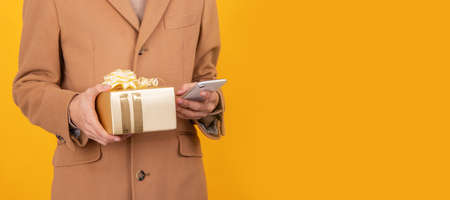 closeup of hands with gift box and mobile phone