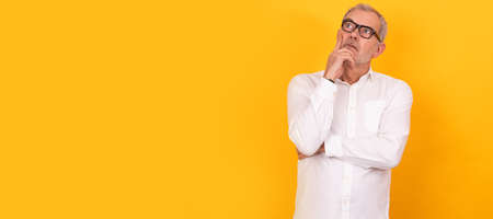 isolated senior adult man with glasses thinking