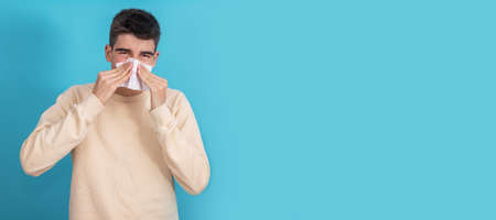 young man with cold with handkerchief isolated on background