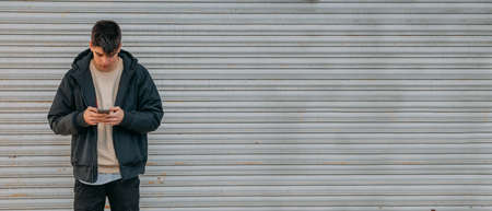 teenager with mobile phone on urban streetの写真素材