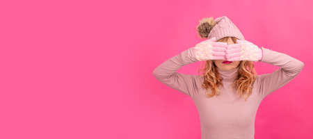 isolated adult woman wearing winter clothes covering eyesの写真素材
