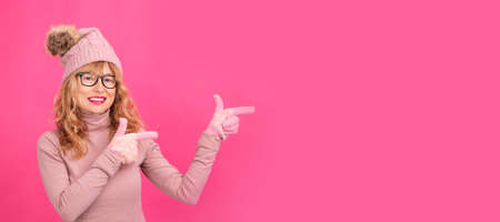 portrait of isolated adult or senior blonde woman pointingの写真素材