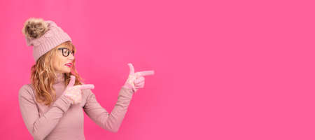 portrait of isolated adult or senior blonde woman pointingの写真素材