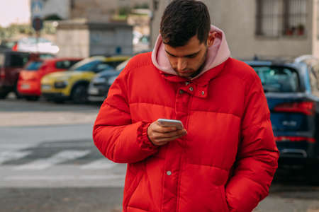 young man with mobile phone on the city streetの写真素材