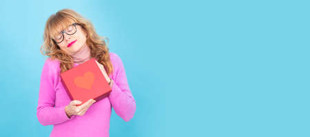 senior woman with valentine gift boxの写真素材