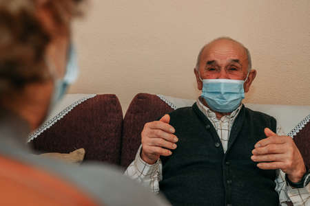 elderly with mask speaking remotely in pandemic
