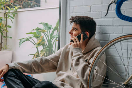 male teenager at home talking on mobile phoneの写真素材