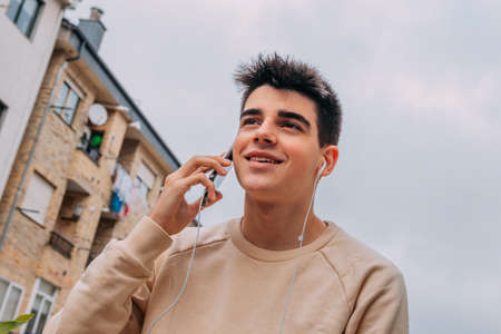 portrait of young teenager with mobile phone in the cityの写真素材