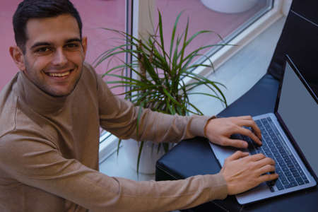young man at home working with laptop