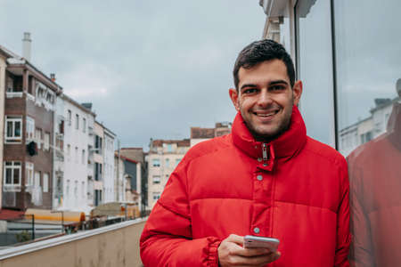 man with mobile phone and warm jacket in the cityの写真素材