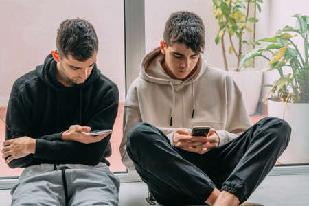 young people at home with mobile phonesの写真素材