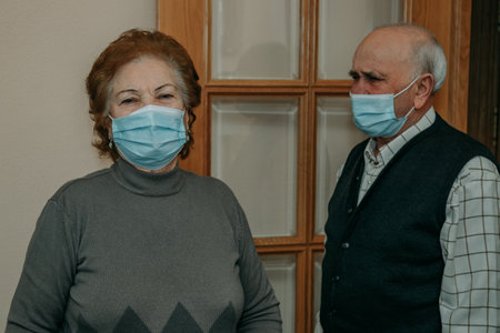 senior couple with face mask at homeの写真素材