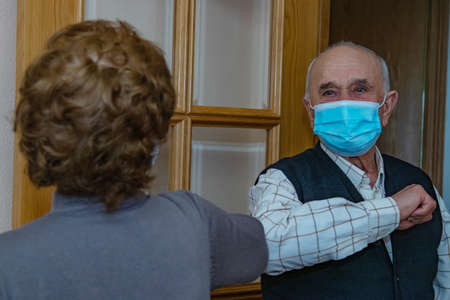 grandparents or seniors saluting each other with a mask in the coronavirus pandemicの写真素材