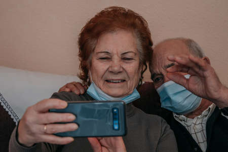 seniors or grandparents talking on mobile phone in video conferenceの写真素材