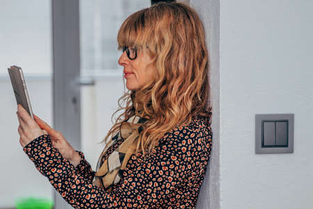 woman with mobile phone at home or officeの写真素材