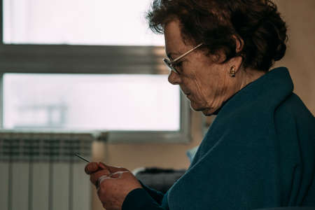 senior woman crocheting or sewing at homeの写真素材