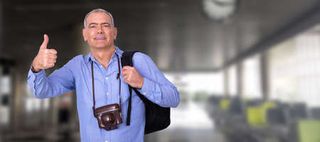 man with camera and luggage at the airportの写真素材