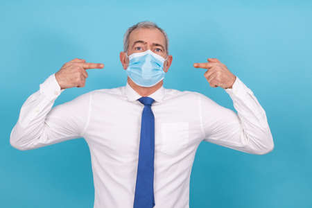 businessman pointing the mask isolatedの写真素材