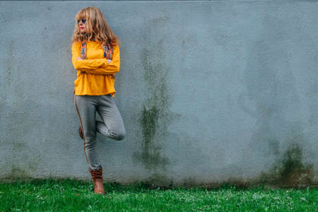 full-length middle-aged woman on the street wallの写真素材