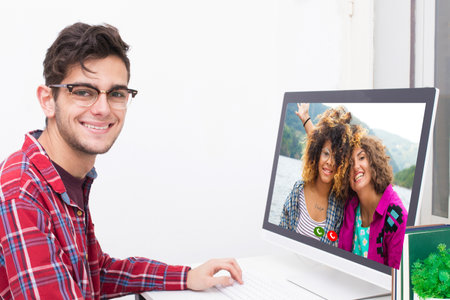 young man at home talking online with friends in video conference