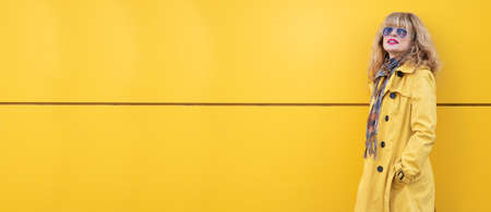 attractive adult woman at yellow wall in the street outdoorsの写真素材