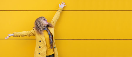 excited woman with raised arms on the streetの写真素材