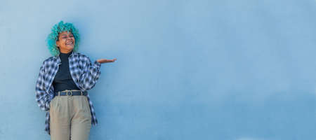 afro american woman on the wall pointing with handの写真素材