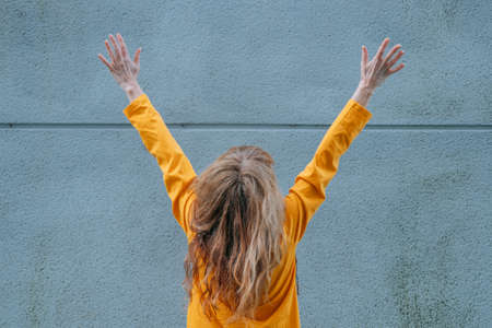 woman with arms raised in the streetの写真素材