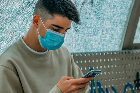 male teenager with mask on the streetの写真素材