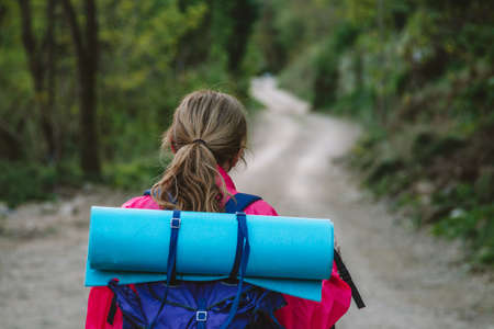 woman with backpack hiking or pilgrimage