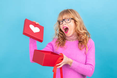 adult woman opening gift box isolated on backgroundの写真素材