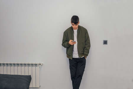 male teenager at home with mobile phoneの写真素材