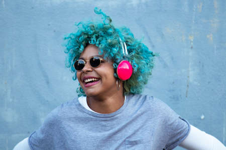 black afro american woman with headphones on the street smiling happyの写真素材