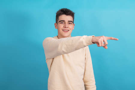 teenager boy pointing isolated on backgroundの写真素材